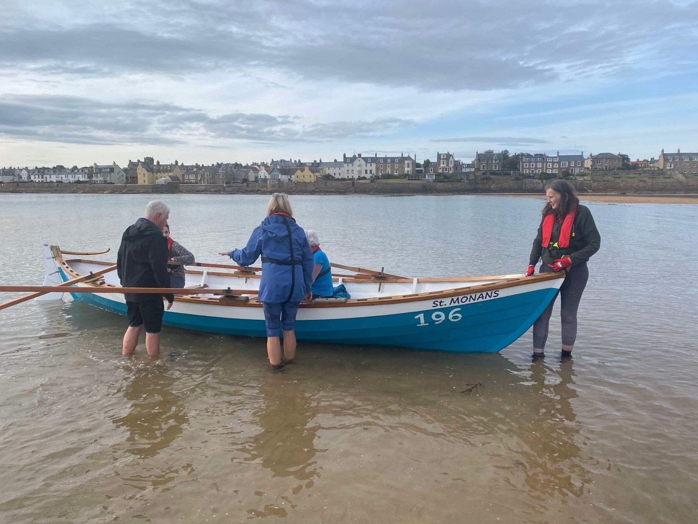 People preparing to row a boat.