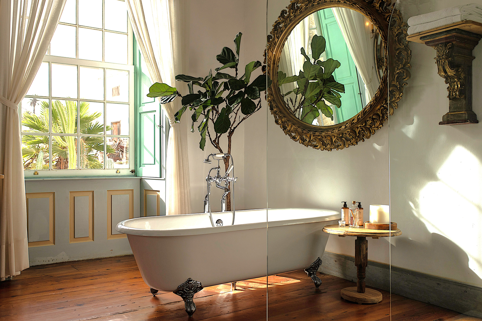 A clear glass panel separates a freestanding bath from a guest room at La Casa de los Naranjos hotel, Lanzarote