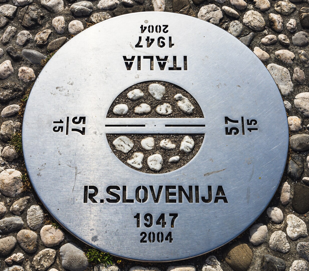 Metal marker indicating the Slovenia-Italy border.