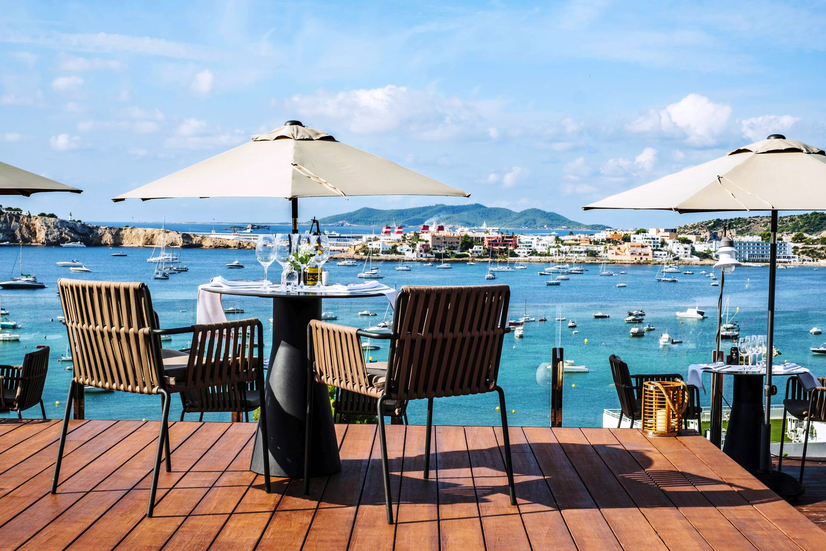 Wine glasses on a table overlooking the bay at Ocean Drive Talamanca, one of the best hotels in Ibiza