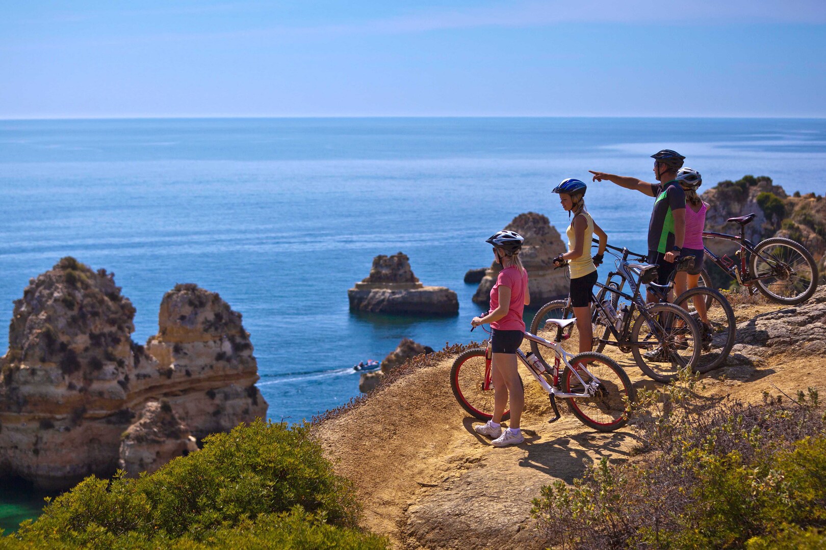 Visitors with bicycles view the ocean at Martinhal Sagres resort in the Algarve, Portugal