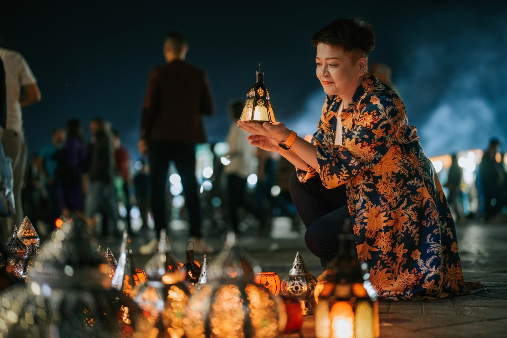 A visitor looks at a lantern at a night market stall in Djemma el-Fna, the main square in Marrakesh.
