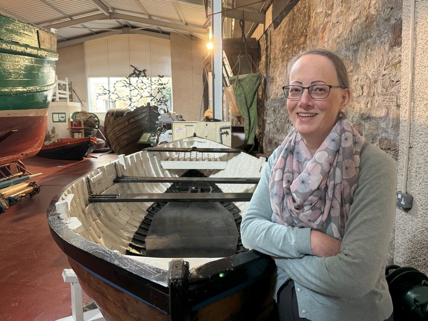 Woman standing by a boat in the Scottish Fisheries Museum.
