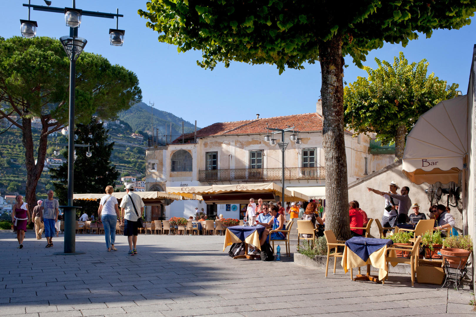 Cafés bustling with tourists in Ravello's main square, Amalfi Coast, Italy.
