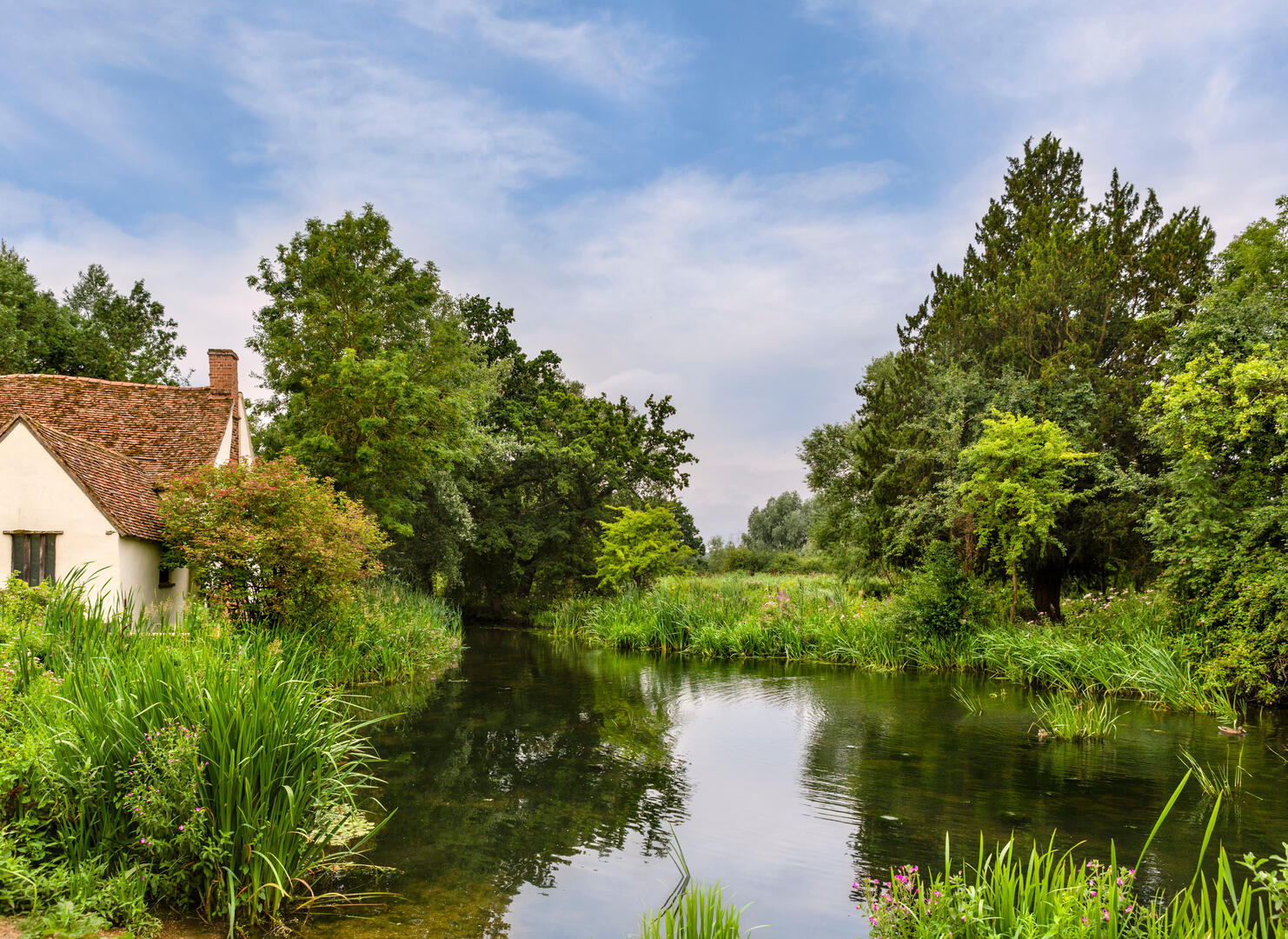 View of Willy Lott's Cottage and Flatford Mill, featured in Constable's painting *The Hay Wain*.