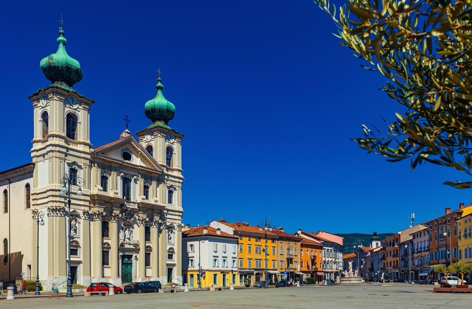 View of Victory Square in Gorizia, Italy, featuring a church and surrounding buildings.