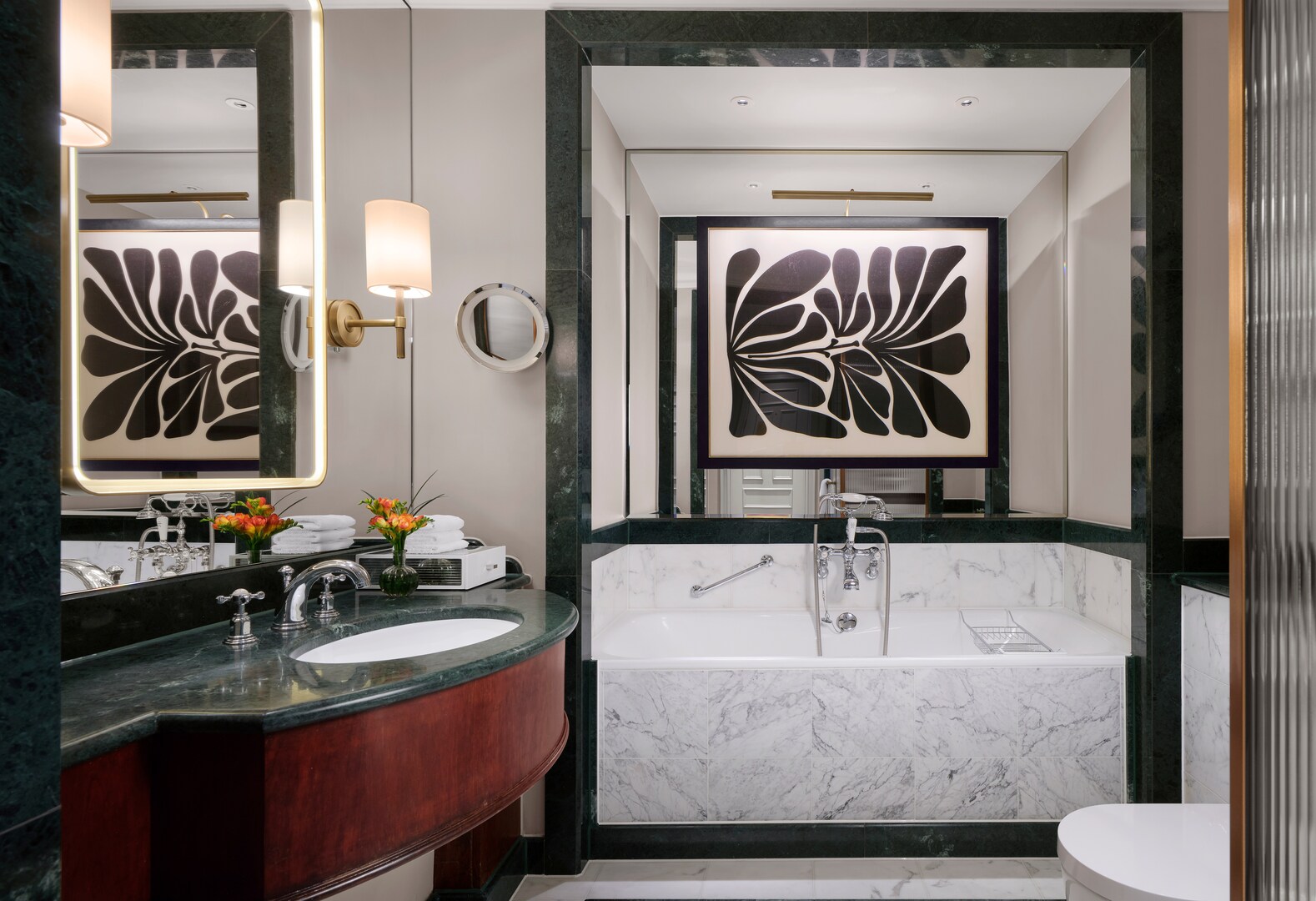 Refurbished Savoy hotel bathroom with marble bathtub and sink.