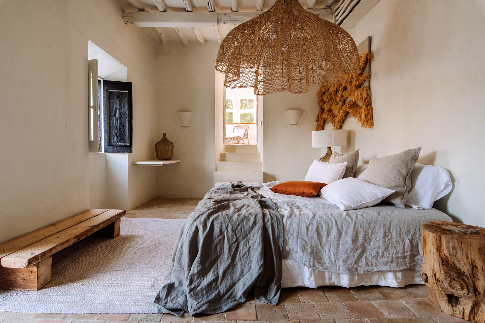 Neutral toned decor and bedding in a guest room at Can Domo, Santa Eularia des Riu, one of the best hotels in Ibiza